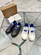 Pair of sneakers: black with blue laces and white with blue patterned laces
