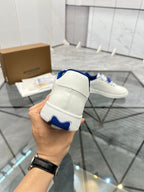 White low-top sneaker heel view with blue sock lining and stitched back tab
