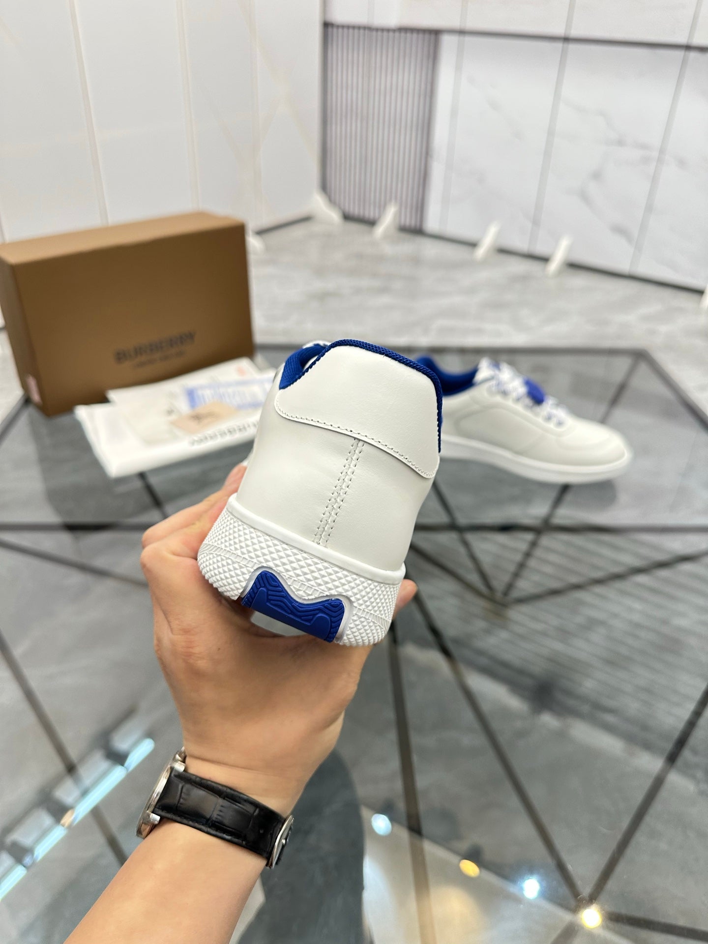 White low-top sneaker heel view with blue sock lining and stitched back tab