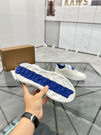 White sneaker outsole view with blue tread panels and embossed details