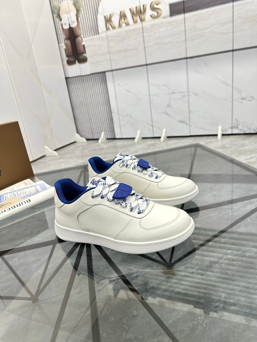 White low-top sneakers with blue lining and layered blue lace detail