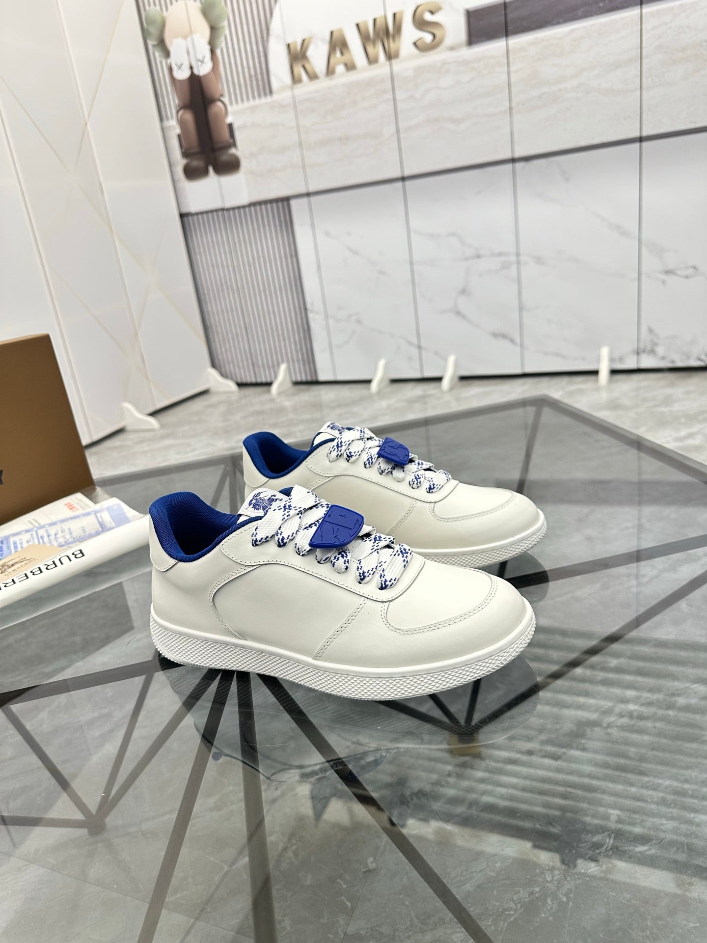 White low-top sneakers with blue lining and layered blue lace detail