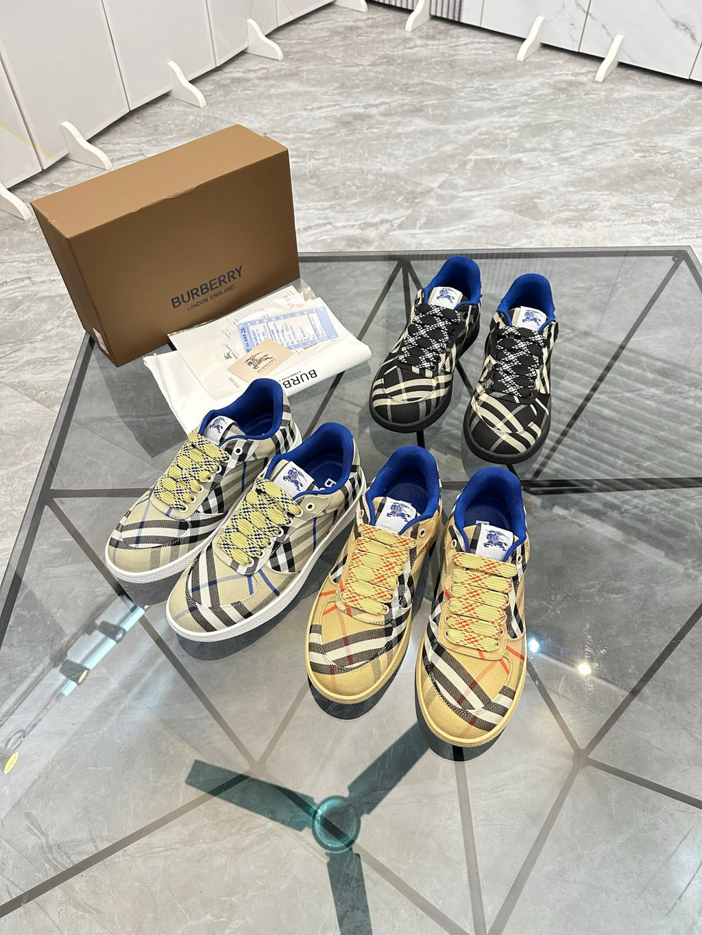 Two pairs of check low-top sneakers with blue trim, lace-up front and tan soles