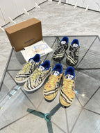 Two pairs of check low-top sneakers with blue trim, lace-up front and tan soles