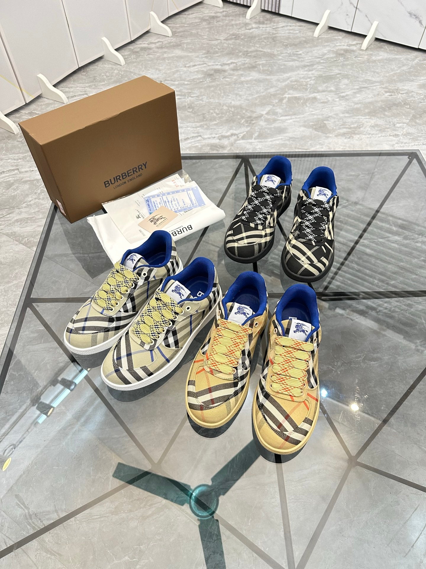 Two pairs of check low-top sneakers with blue trim, lace-up front and tan soles