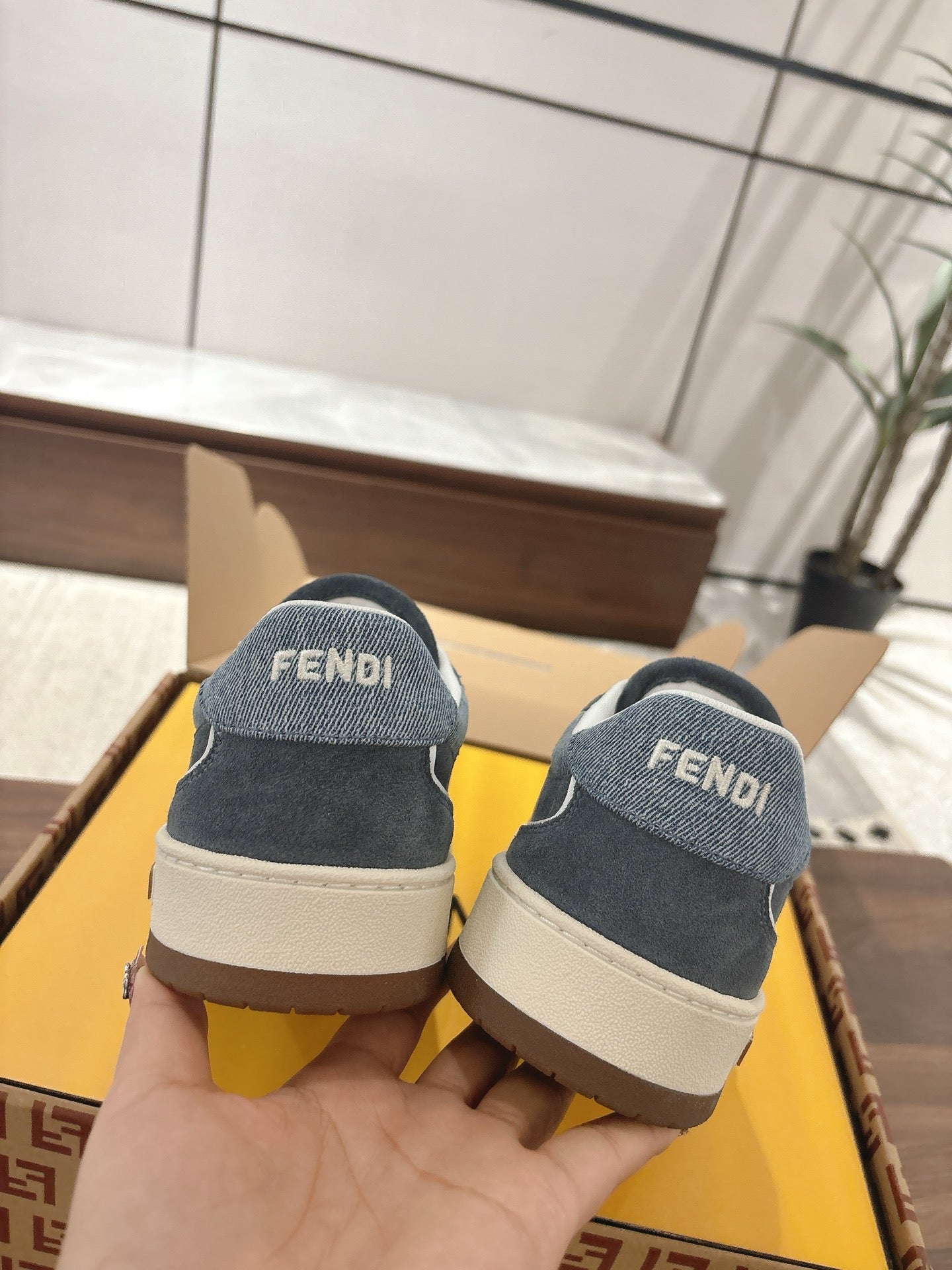 Fendi unisex sneakers from heel, dark blue fabric with white midsole and FENDI lettering.