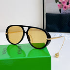 Sunglasses with black frame, gold accents, and yellow mirrored lenses.