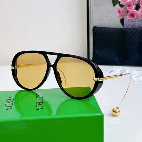 Sunglasses with black frame, gold accents, and yellow mirrored lenses.