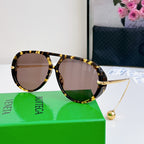 Sunglasses with tortoiseshell frame and brown tinted lenses; gold hardware.