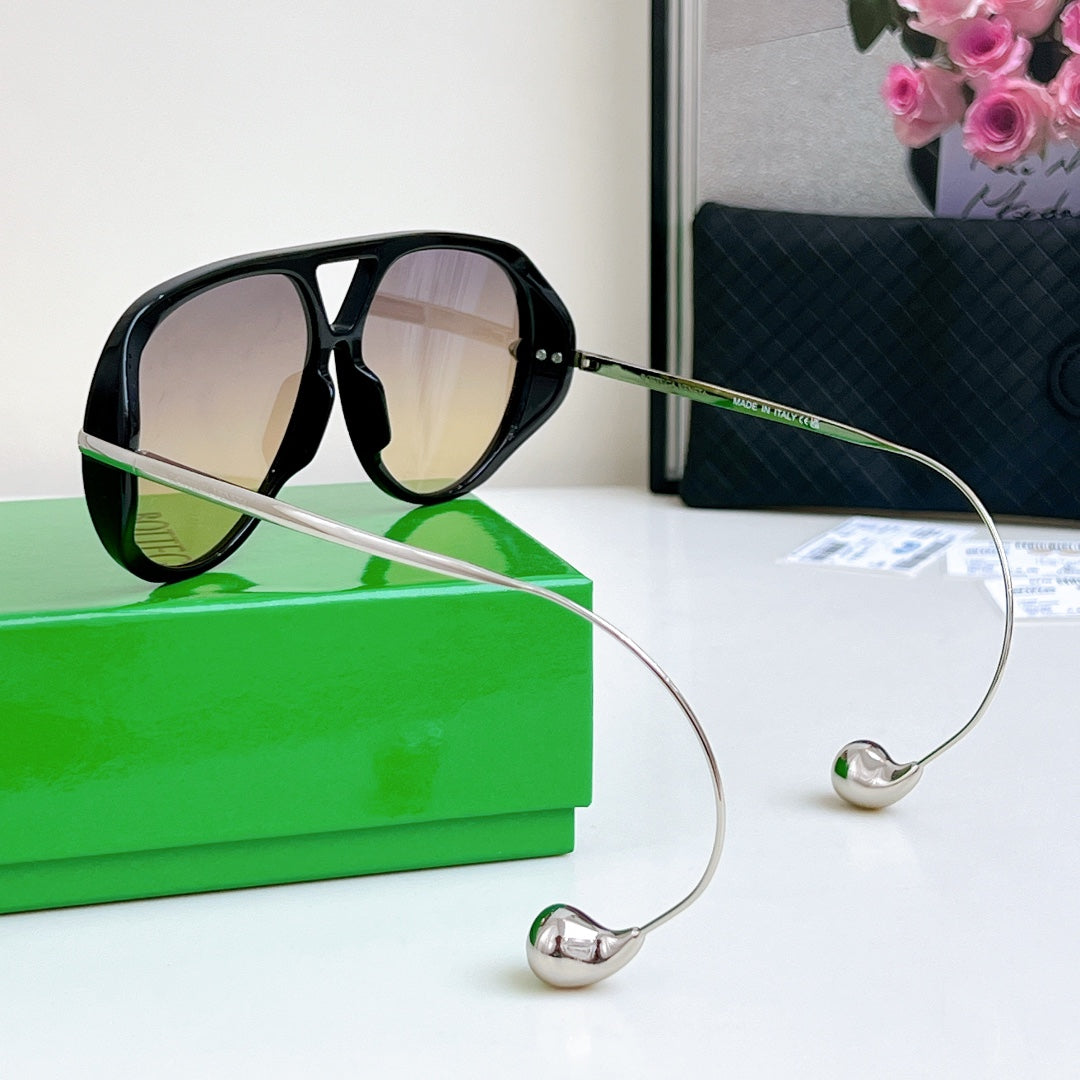 Sunglasses with black frame, silver arms, and gradient lenses; metal cord tips.