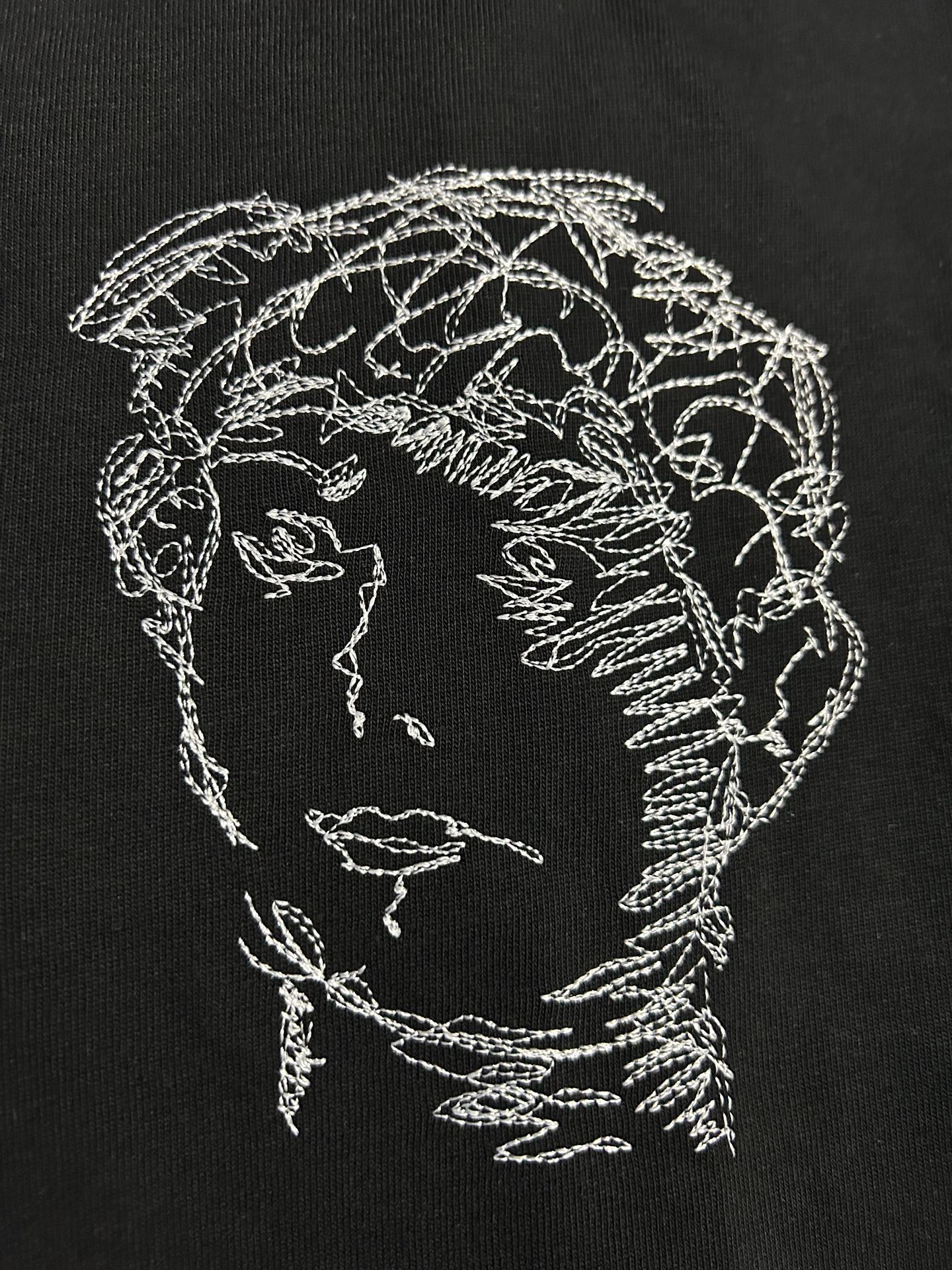 Off-White T-shirt close-up of white line-art head and shoulder graphic