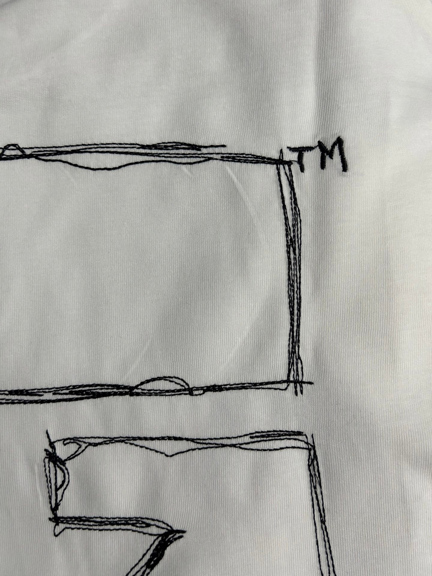 Off-White off-white T-shirt close-up of black X graphic corner and TM