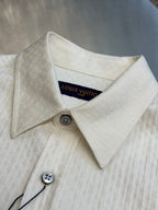 Cream long-sleeve shirt detail of spread collar and button at neckline with inner tag