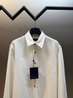 Cream long-sleeve button-up shirt with textured fabric, spread collar, and hanging tag