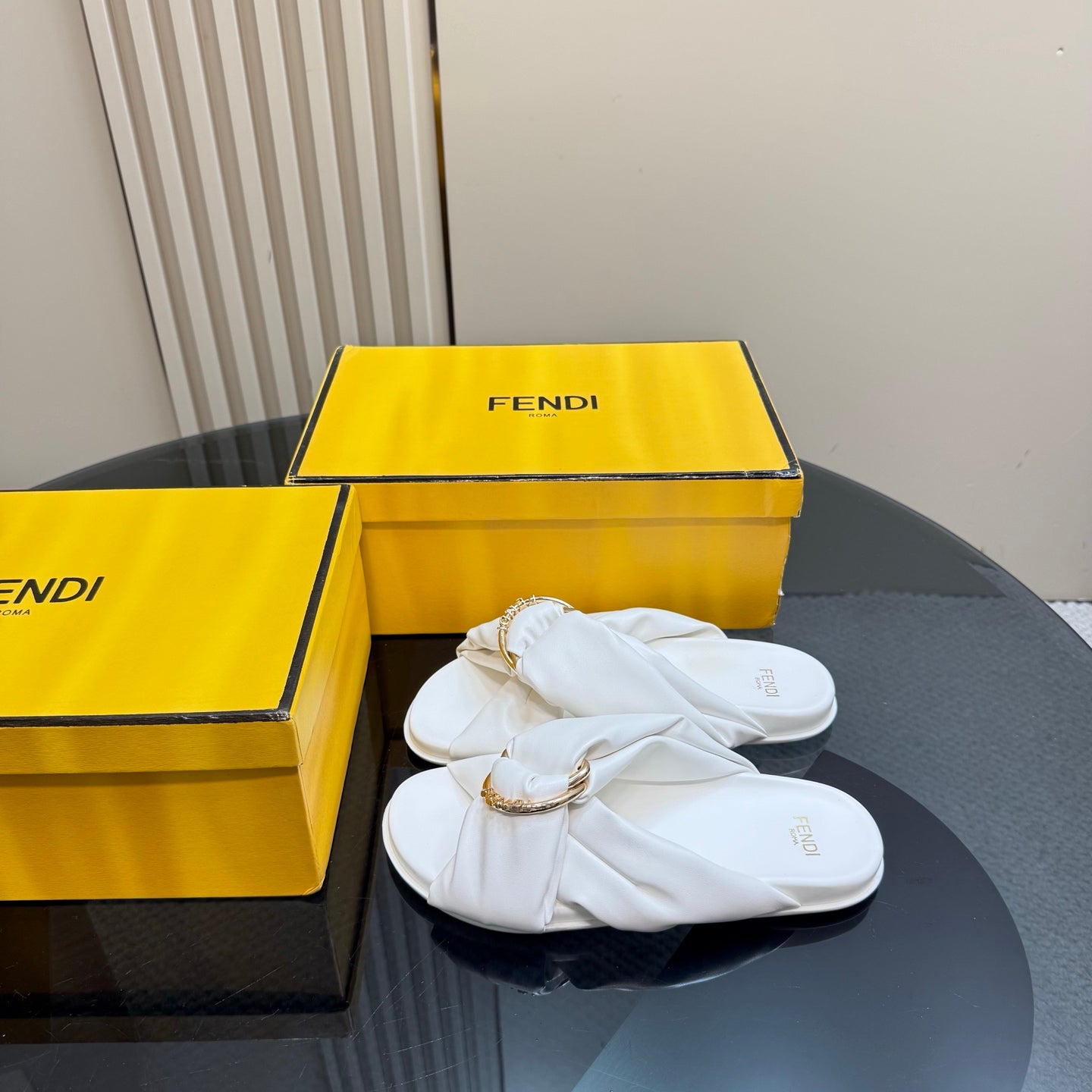 White Fendi slide sandals with gold chain and twisted strap detail