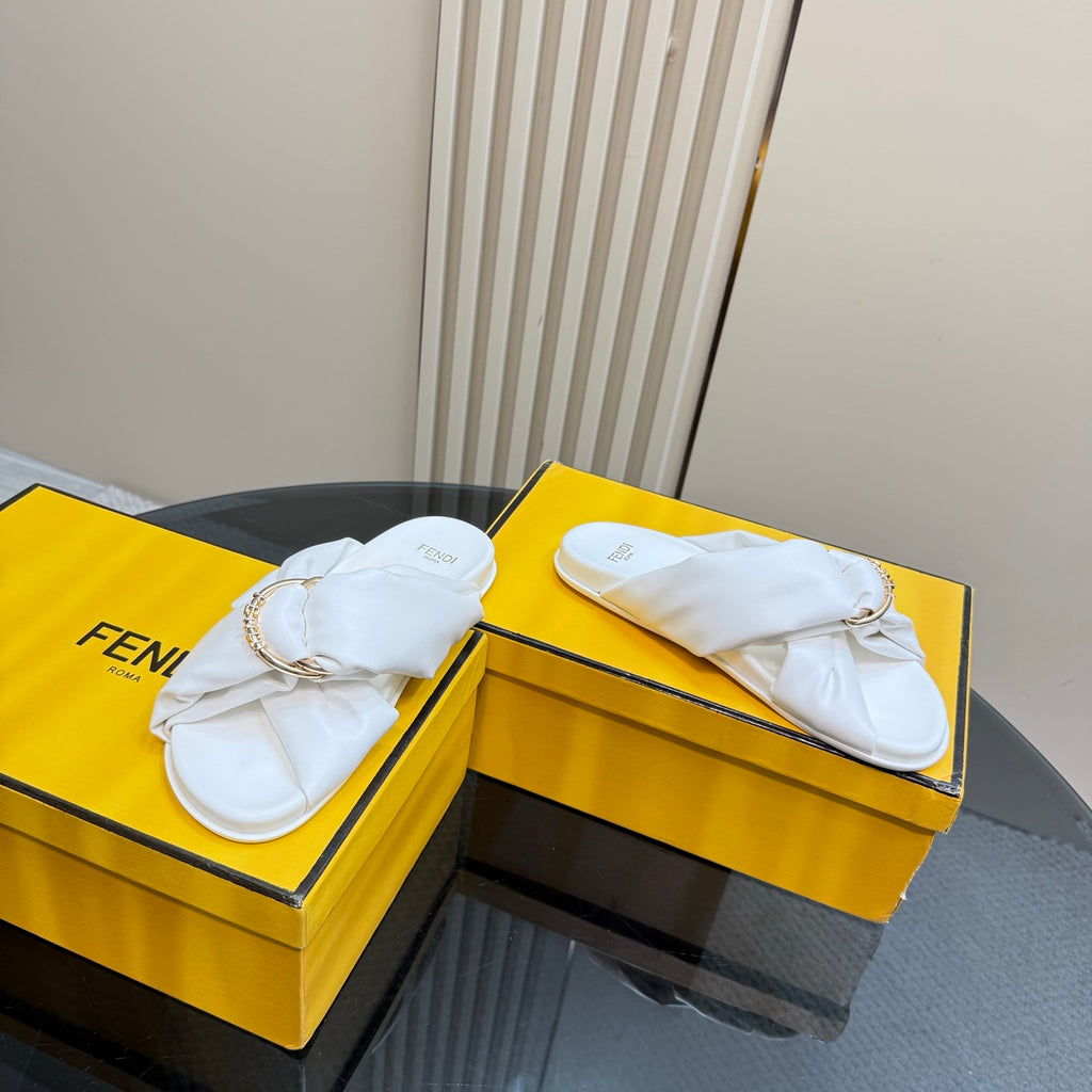 White Fendi slide sandals with gold chain detail, side-by-side on boxes