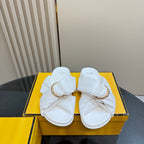 Pair of white Fendi slide sandals with gold chain buckle and twisted straps