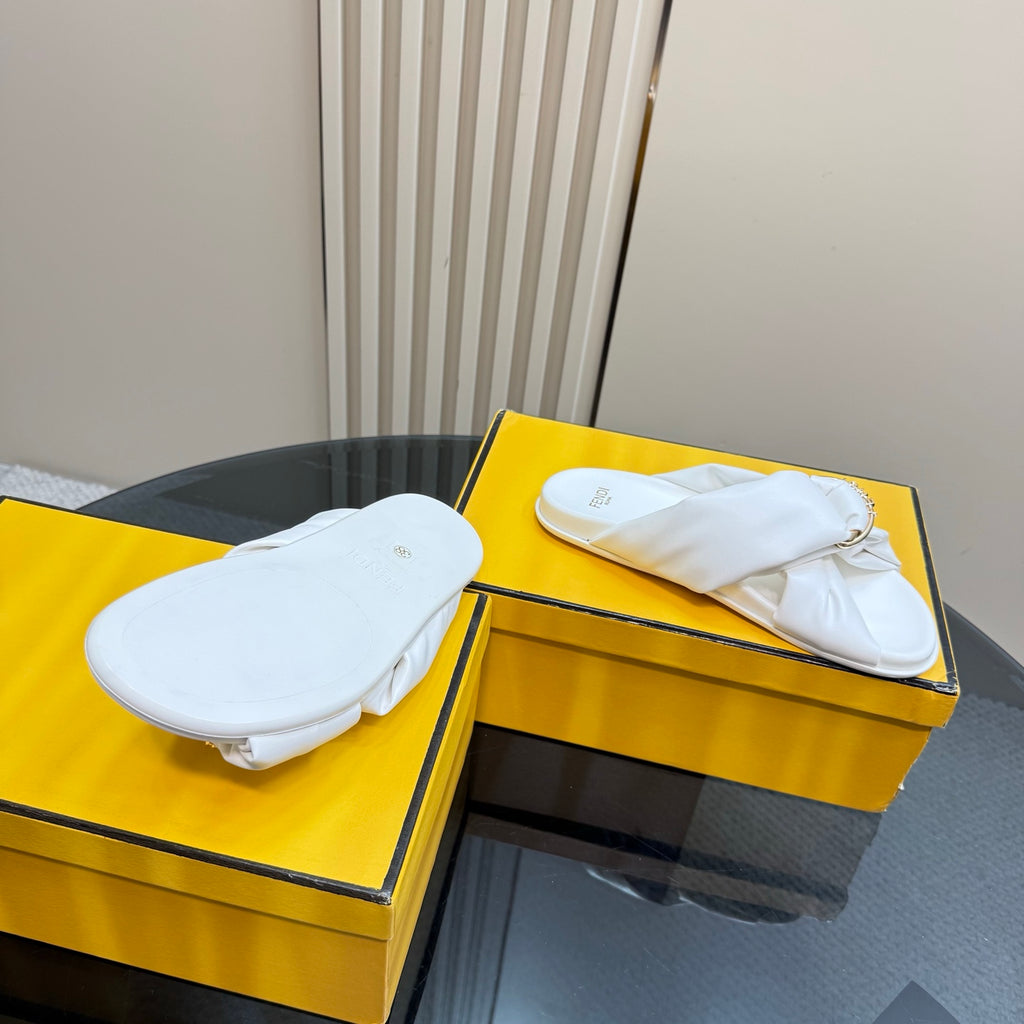 White Fendi slide sandals with gold chain straps, shown from above