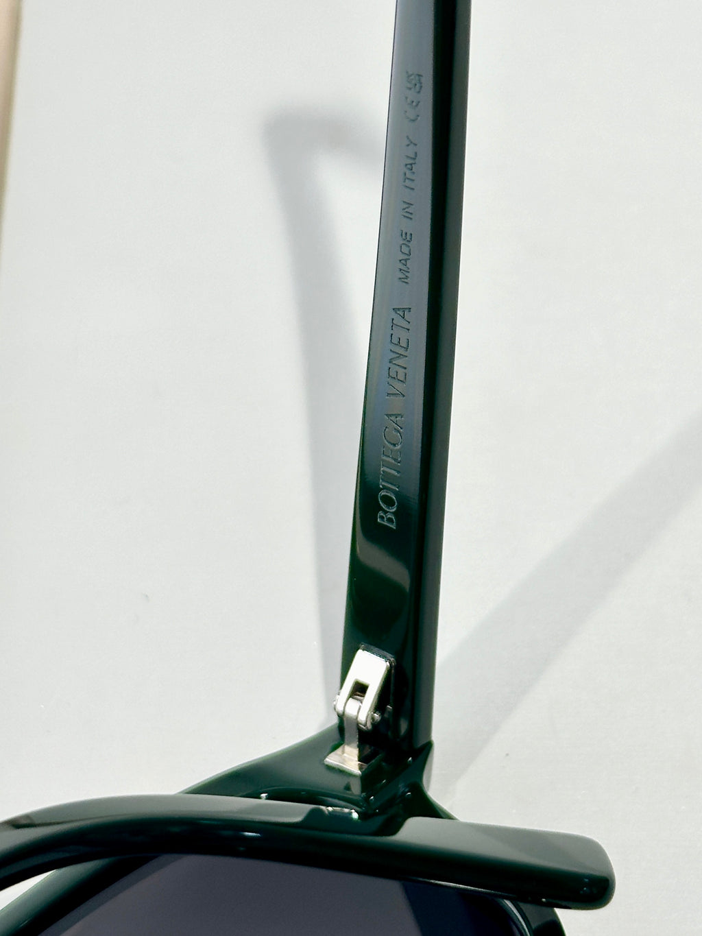 Bottega Veneta glasses with dark green temple and brand text detail