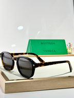 Bottega Veneta glasses with tortoiseshell accents and dark tinted lenses