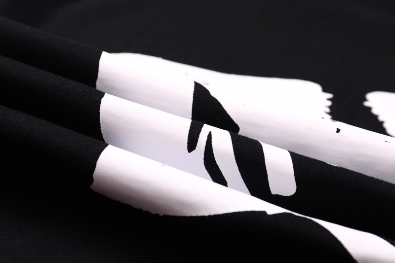 Black T-shirt close-up of sleeve/side graphic in white print