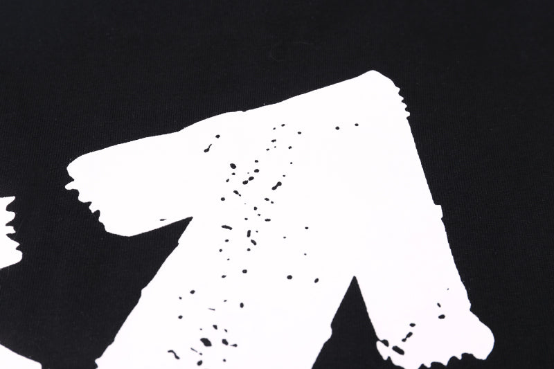 Black T-shirt close-up of large white graphic print with small speckles