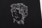 Black T-shirt close-up of line-art face profile graphic