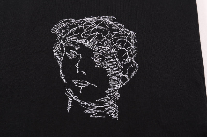 Black T-shirt close-up of line-art face profile graphic