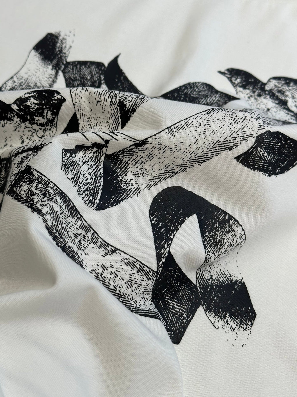 White T-shirt fabric with bold black bird pattern