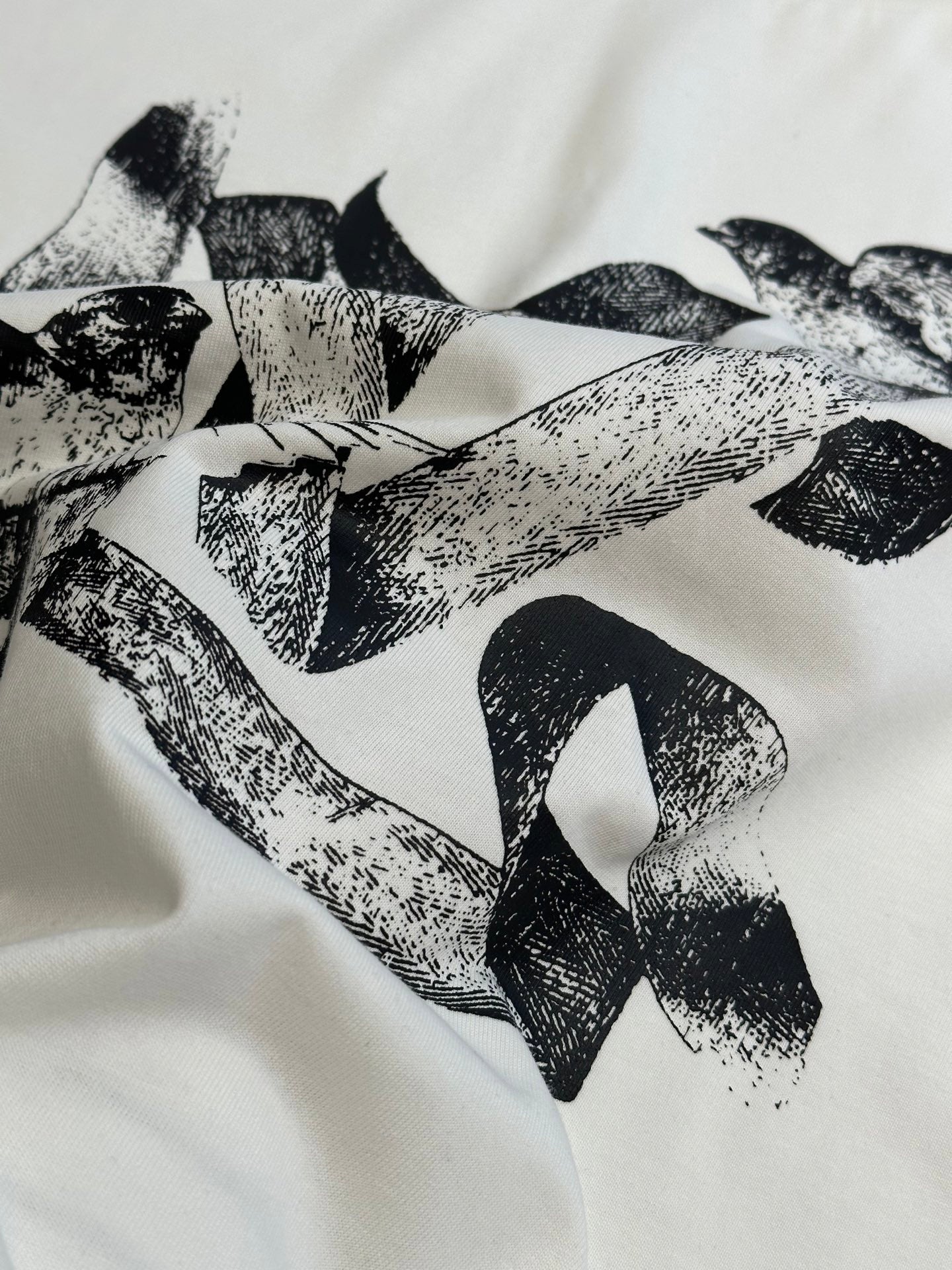 White T-shirt fabric with bold black bird pattern