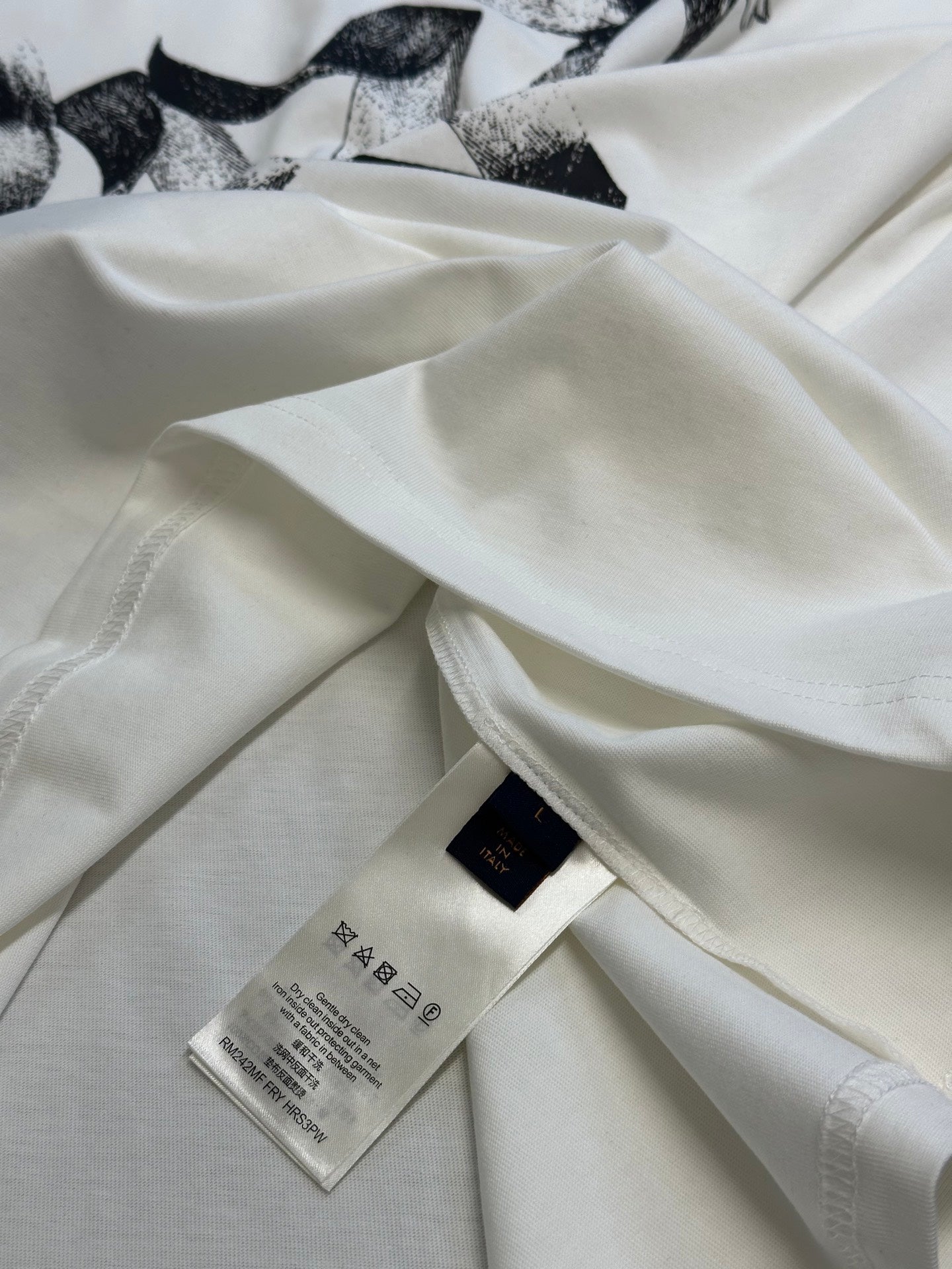 White T-shirt with hang tag and care label visible on the fabric