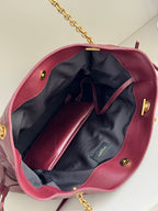 YSL burgundy tote bag interior with navy lining, open top, and gold hardware accents