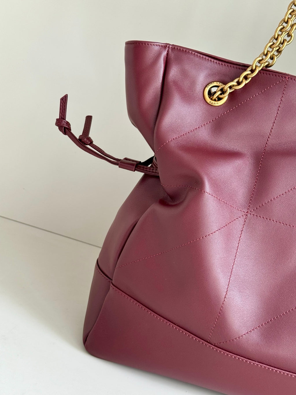 YSL burgundy leather tote with quilted panels and bow-like strap ties on side