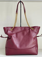 YSL quilted tote bag with burgundy leather, gold chain handles, and side pouch detail