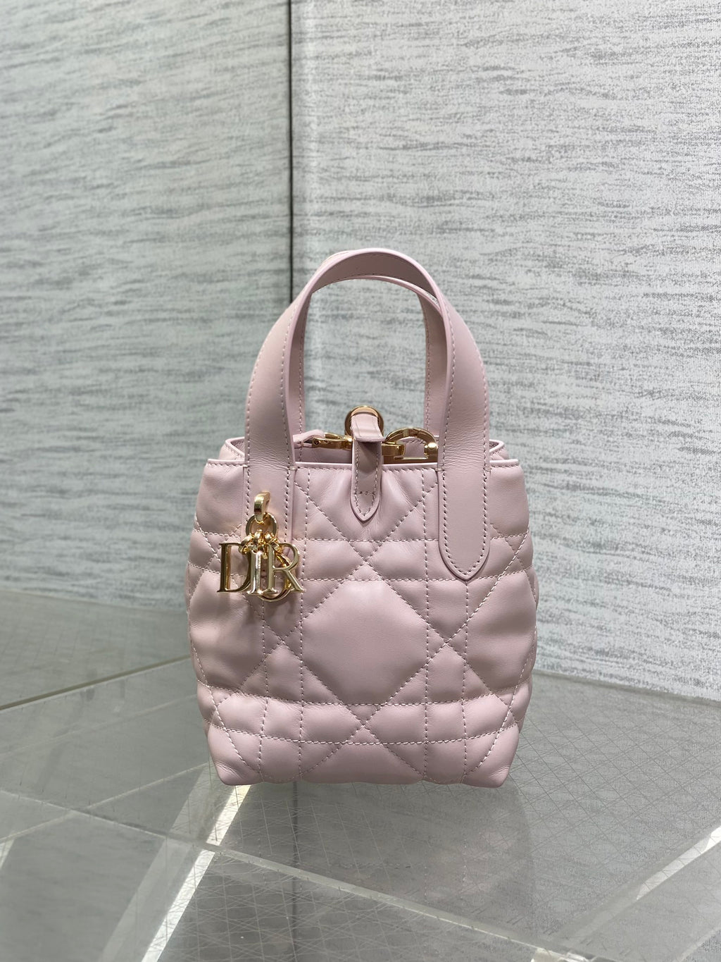 Pink quilted Dior handbag with top handle and gold front clasp