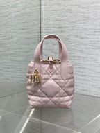 Pink quilted Dior handbag with top handle and gold front clasp