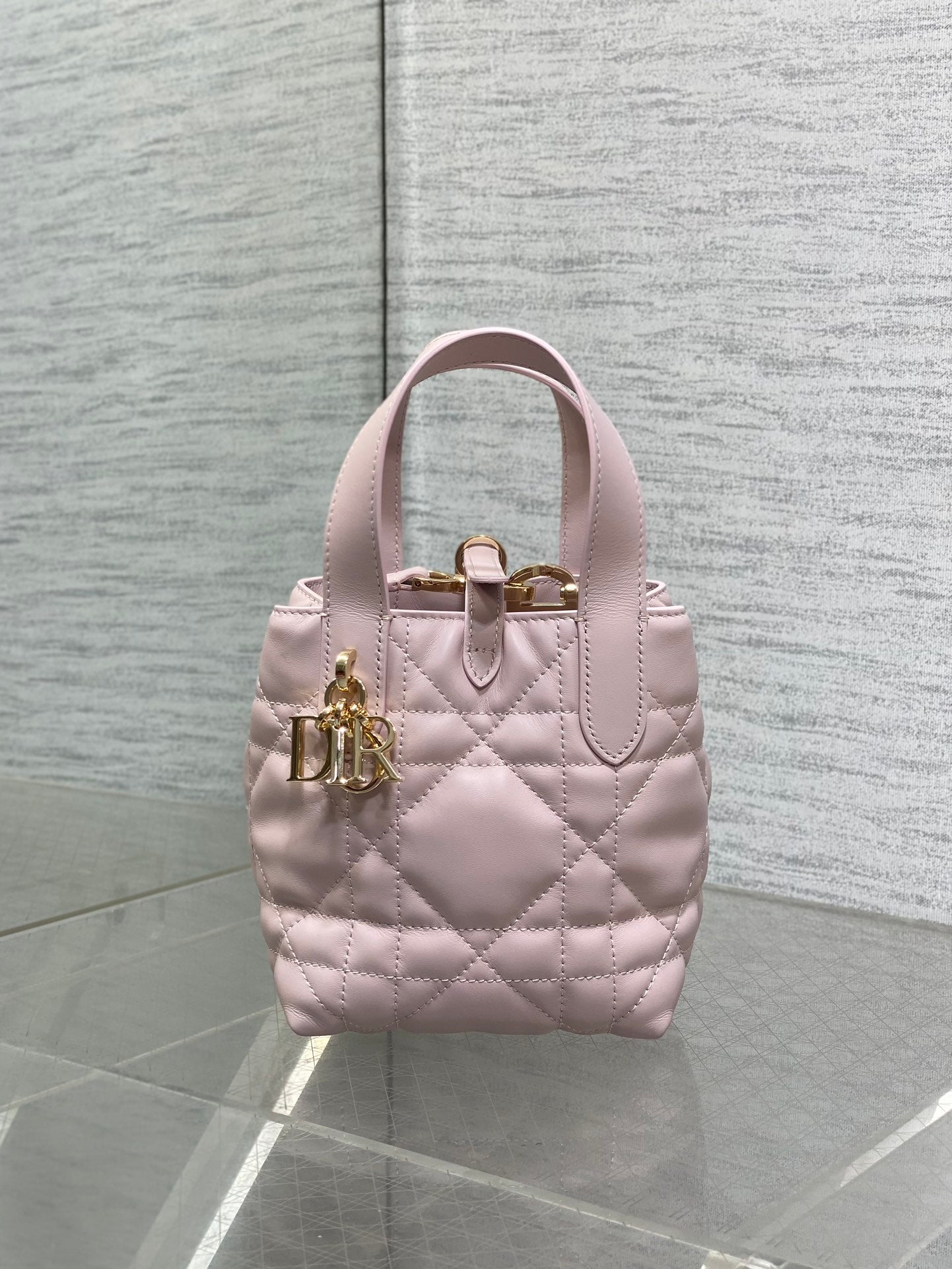 Pink quilted Dior handbag with top handle and gold front clasp