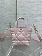 Pink Dior mini handbag with dual top handles, quilted front, and gold clasp