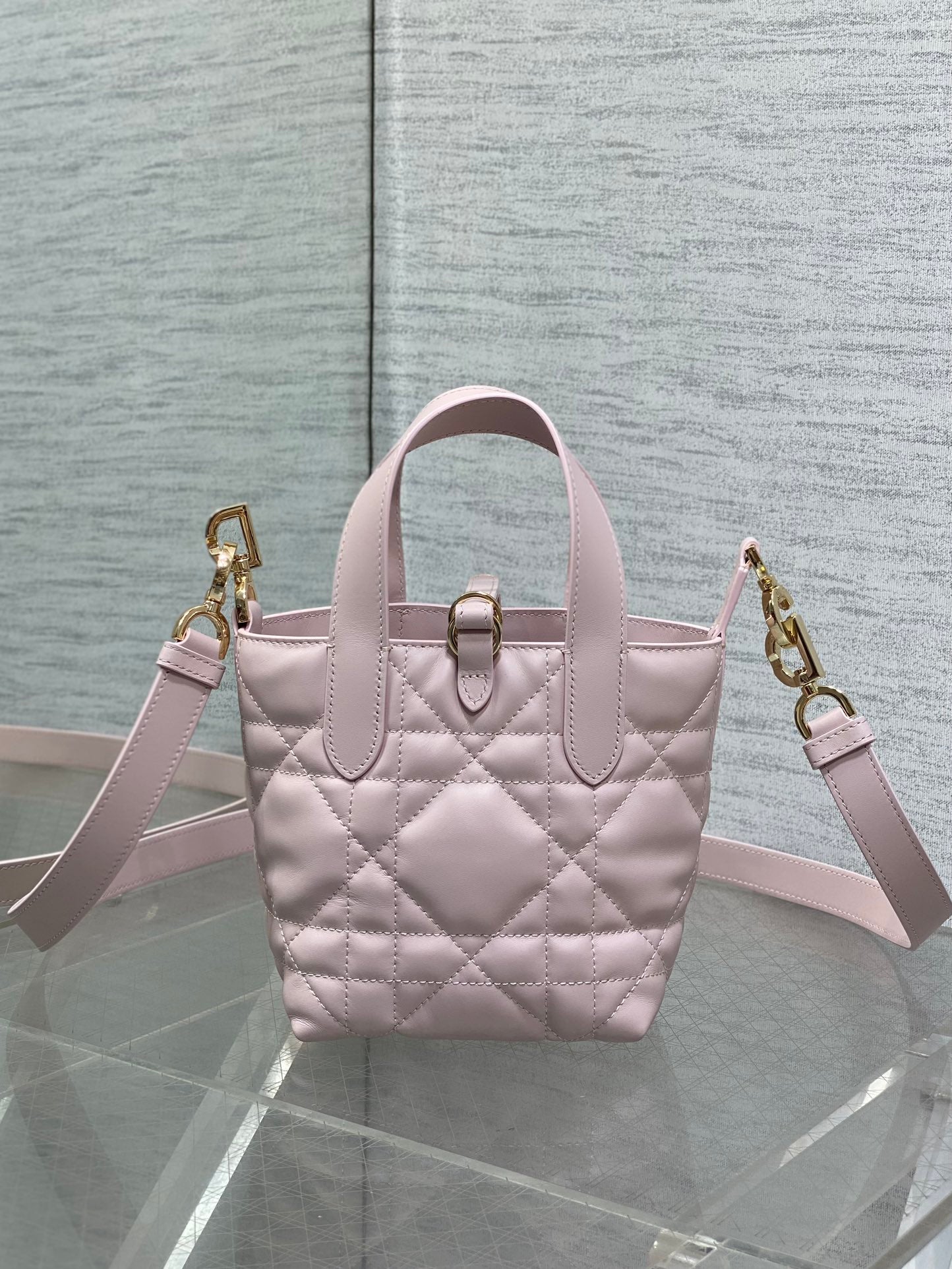 Pink Dior mini handbag with dual top handles, quilted front, and gold clasp
