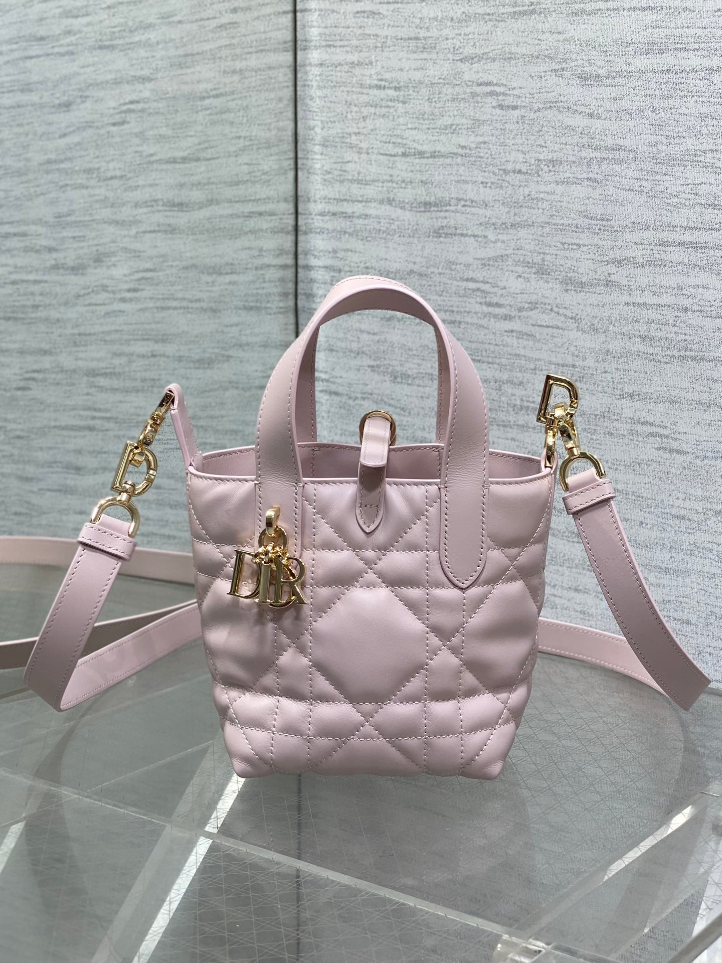 Pink Dior handbag with shoulder straps, quilted pattern, and gold hardware