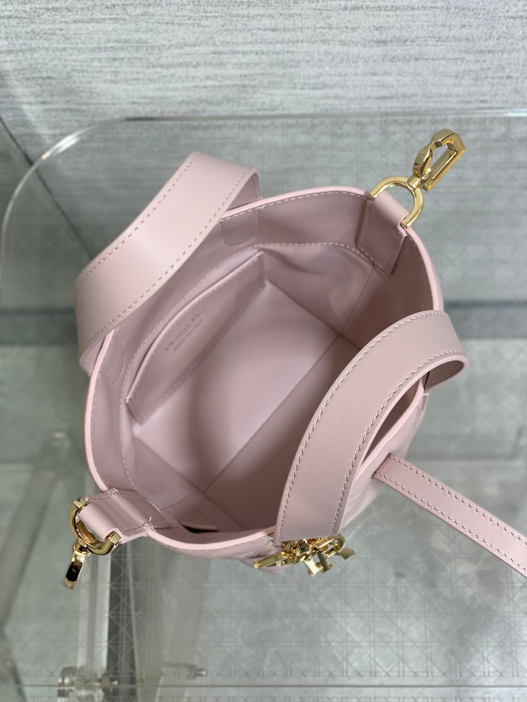Pink Dior handbag interior with adjustable shoulder strap and gold-tone hook