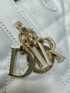 Dior charm detail on quilted white leather bag, gold clasp and hardware