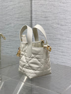 Dior quilted mini tote bag side view, white leather, gold charm and shoulder strap