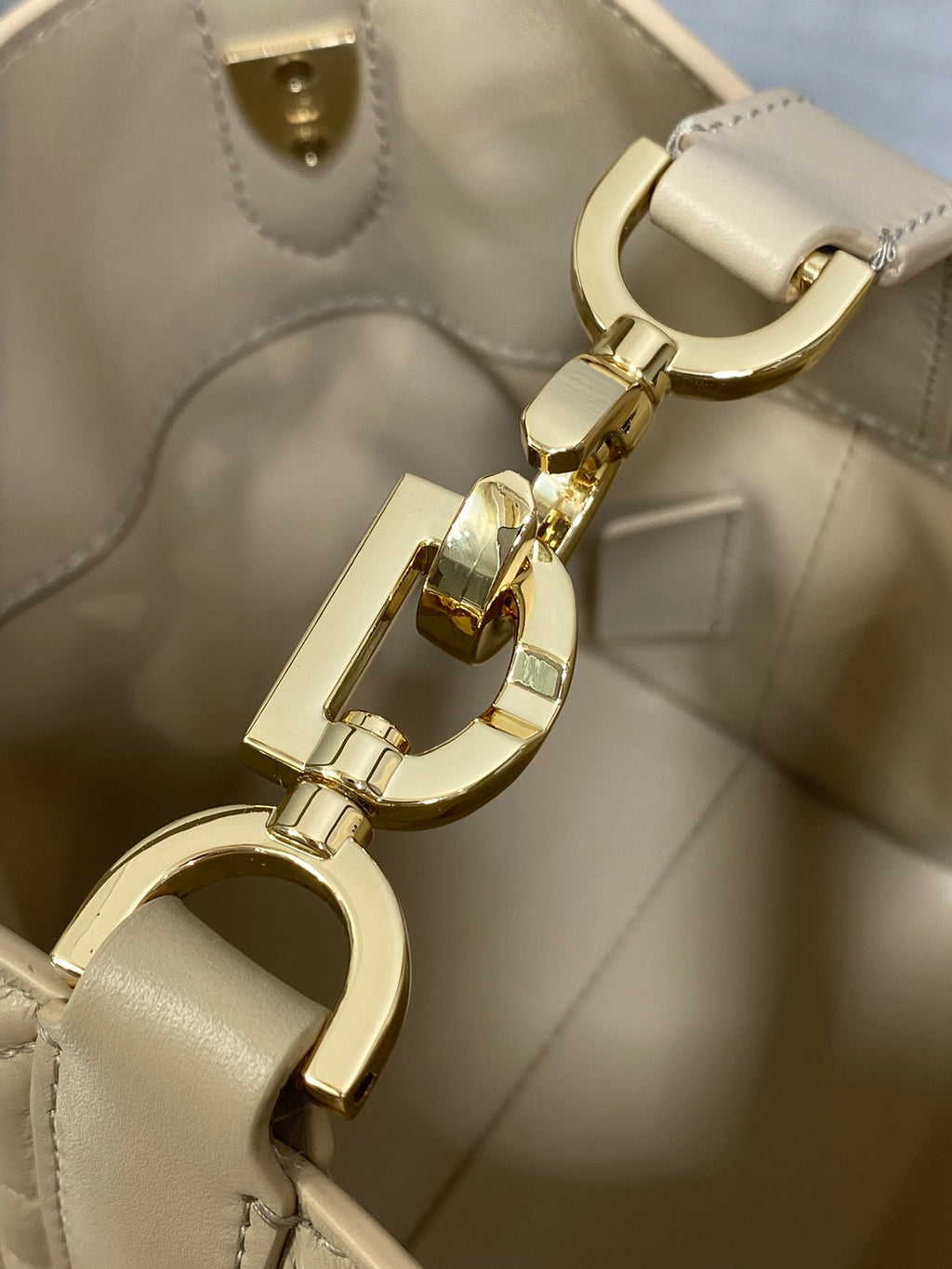 Dior handbag clasp and keyring hardware close-up in gold tone