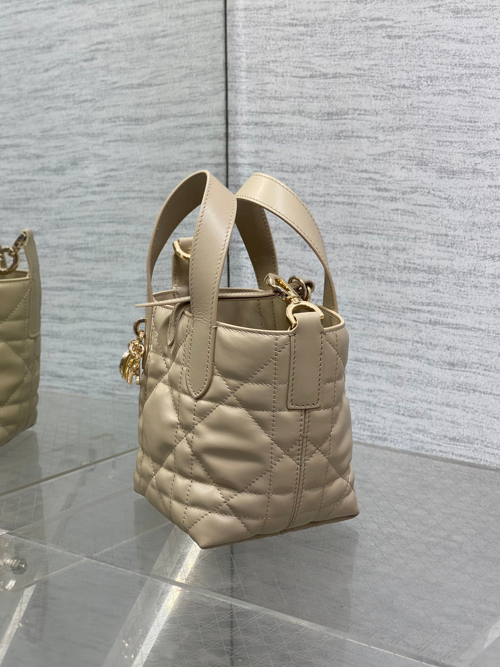 Dior quilted mini handbag side view with top handle and gold hardware