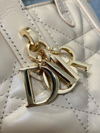 Dior handbag hardware close-up with gold letters and charm on quilted leather