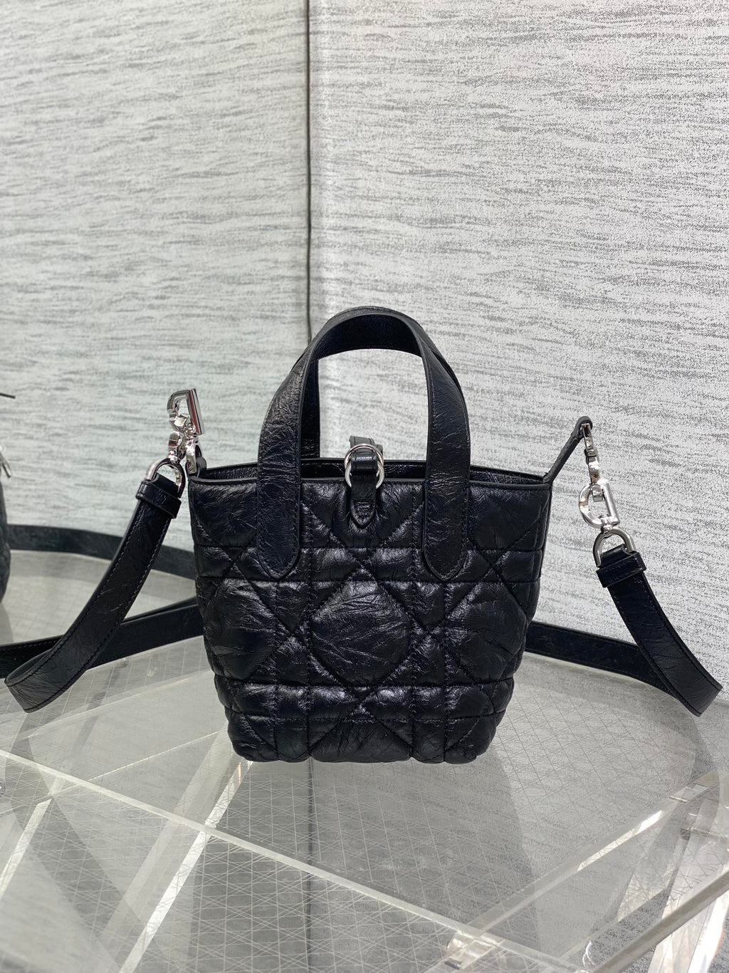 Black quilted mini handbag with top handle and crossbody straps