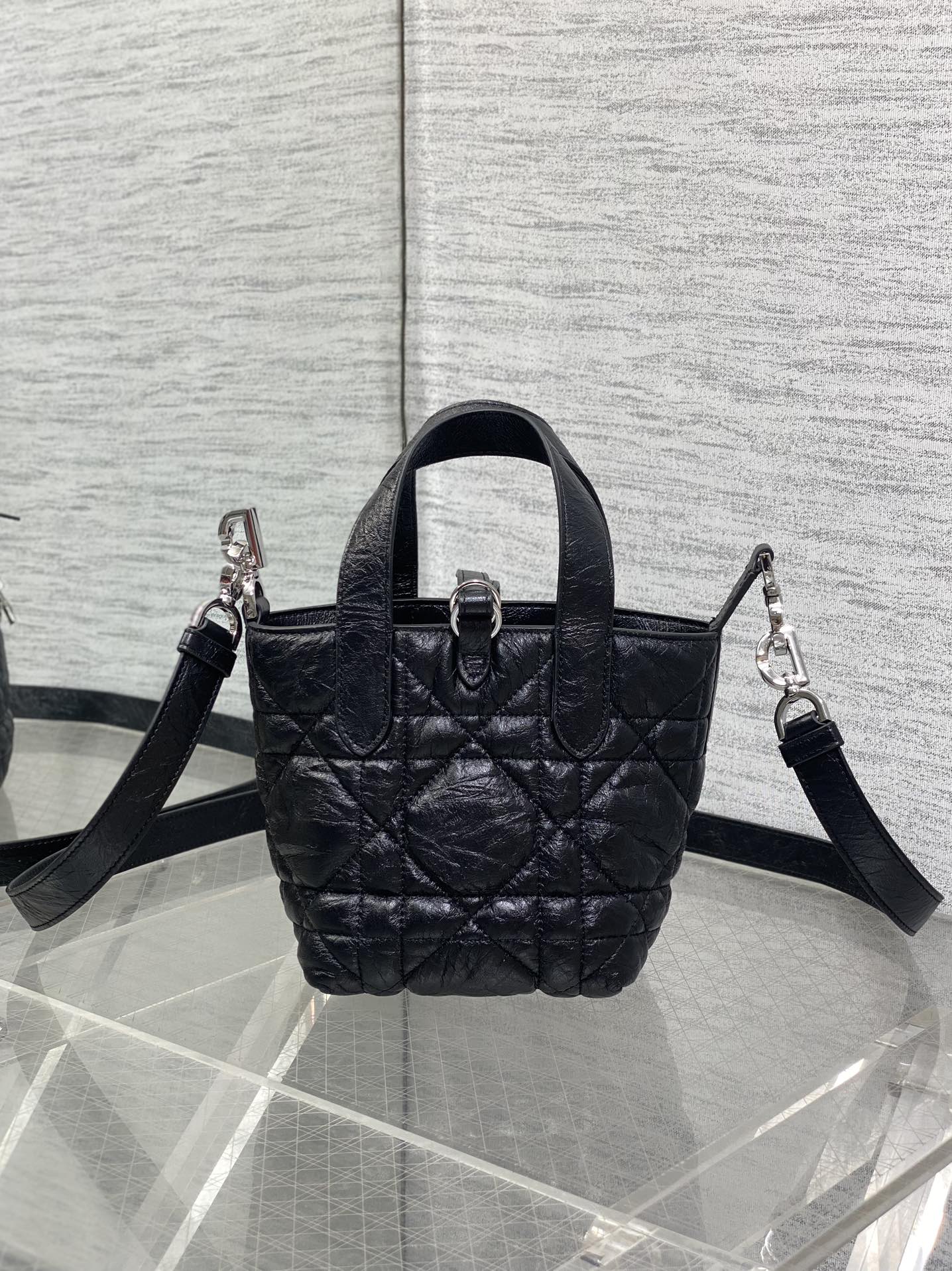Black quilted mini handbag with top handle and crossbody straps