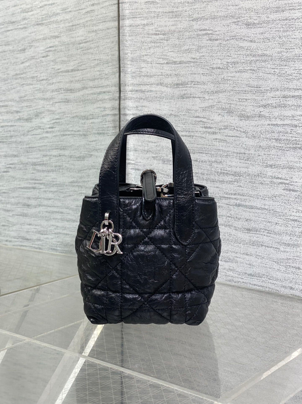 Black quilted mini handbag with top handle and front clasp