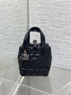 Black quilted mini handbag with top handle and front clasp